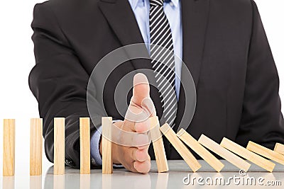 Businessman hand stop dominoes continuous toppled Stock Photo