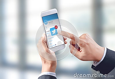 Businessman hand touch twitter icon on mobile screen Editorial Stock Photo