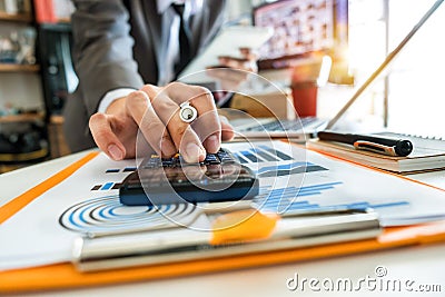 Businessman hand working with finances about cost and calculator and laptop Stock Photo