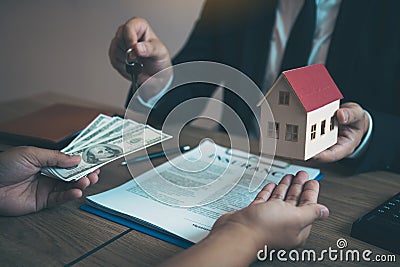 Businessman handed the house model and new homeowner giving money to real estate trading Stock Photo