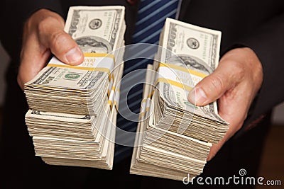 Businessman Handing Over Stacks of Money Stock Photo