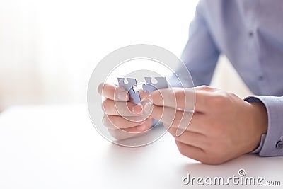 Businessman hands connecting jigsaw puzzle. Business solutions, success and strategy, learning concept. Close up photo Stock Photo