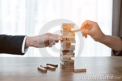 Businessman hands play wood block tower game Stock Photo