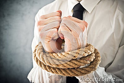 Businessman with hands tied in ropes Stock Photo