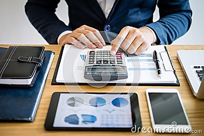 Businessman hands using text information on digital tablet to analyze financial statistical chart data and calculate cost of Stock Photo