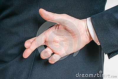 Businessman has crossed fingers behind his back. Good luck or dishonesty concept Stock Photo