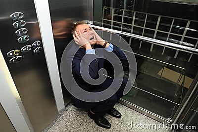 Businessman having panic attack in elevator Stock Photo