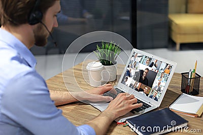 Businessman in headphones speak talk on video call with colleagues on online briefing during self isolation Stock Photo