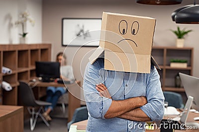 Business man wearing sad face cardboard Stock Photo