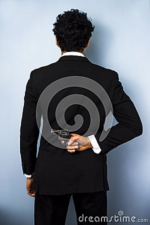 Businessman hiding gun behind his back Stock Photo
