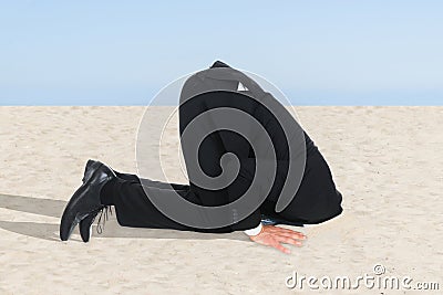 Businessman hiding his head in sand Stock Photo