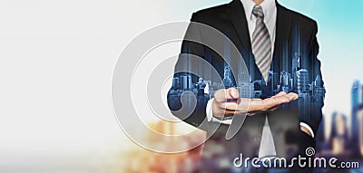 Businessman holding blue hologram of modern buildings, with blur background and copy space Stock Photo