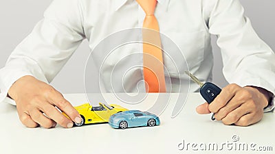 Businessman holding a car keys and miniature car model, Auto business and financial concept Stock Photo