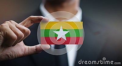 Businessman Holding Card of Myanmar Flag Stock Photo