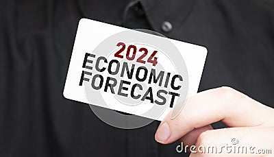 Businessman holding a card with text 2024 ECONOMIC FORECAST, business concept Stock Photo