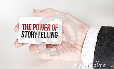 businessman holding a card with text THE POWER OF STORYTELLING Stock Photo