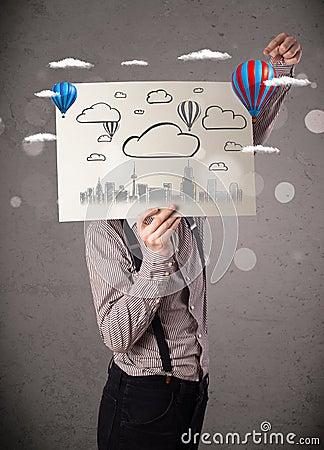 Businessman holding a cardboard with cityscape in front of his h Stock Photo