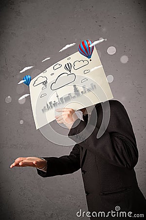 Businessman holding a cardboard with cityscape in front of his h Stock Photo