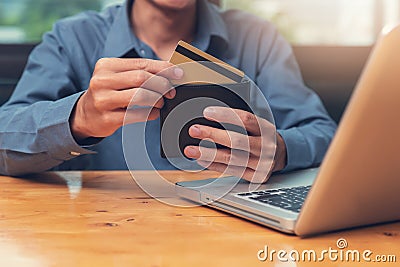 Businessman holding credit cart to shopping online with computer laptop in cafe Editorial Stock Photo