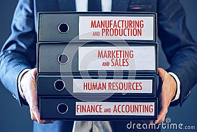 Businessman holding document binders with four major business functions Stock Photo