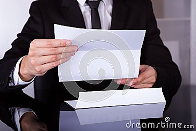 Businessman holding document at desk Stock Photo