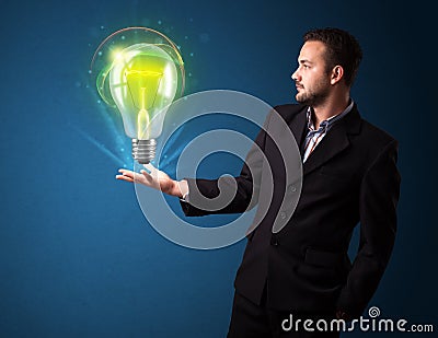 Businessman holding glowing lightbulb in his hand Stock Photo