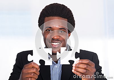 Businessman Holding Jigsaw Puzzle Stock Photo