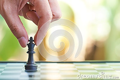 Businessman holding a King Chess is placed on a chessboard. using as background business concept and Strategy concept with copy sp Stock Photo