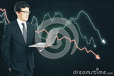 Businessman holding laptop and drawing crisis chart Stock Photo