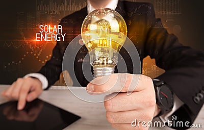 Businessman holding a lightbulb Stock Photo