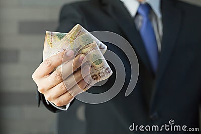 Businessman holding money thai baht Stock Photo