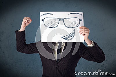 Businessman holding a paper with smiley face in front of his head Stock Photo