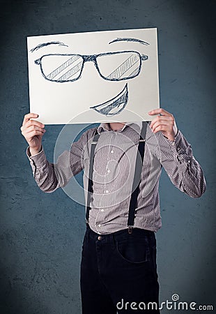 Businessman holding a paper with smiley face in front of his head Stock Photo