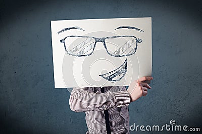 Businessman holding a paper with smiley face in front of his head Stock Photo