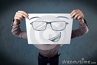 Businessman holding a paper with smiley face in front of his head Stock Photo