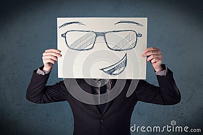 Businessman holding a paper with smiley face in front of his head Stock Photo