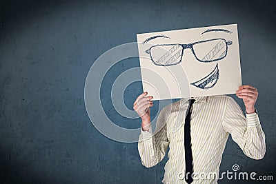 Businessman holding a paper with smiley face in front of his head Stock Photo