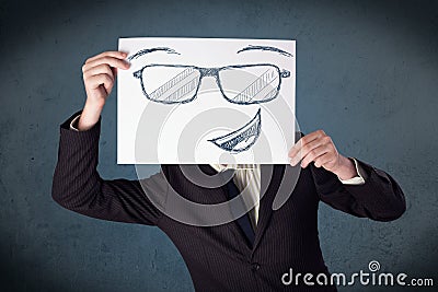 Businessman holding a paper with smiley face in front of his hea Stock Photo
