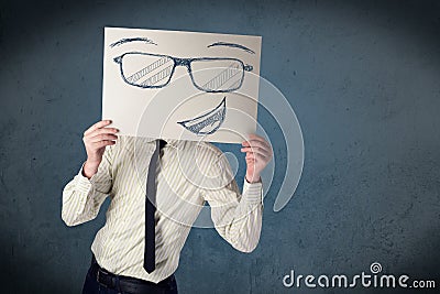 Businessman holding a paper with smiley face in front of his hea Stock Photo