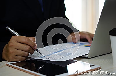 Businessman holding pen to work computer graphs and charts data statistical data financial analysis documents Stock Photo