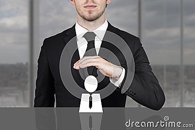 Businessman holding protective hand above employee Stock Photo