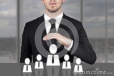 Businessman holding protective hand above employee staff Stock Photo