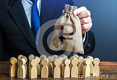 A businessman is holding a russian ruble money bag over a crowd of people figurines. Staff maintenance, tax collection, provide Stock Photo