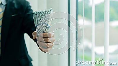 Businessman holding several $100 bills in his hand, payroll concept. Stock Photo