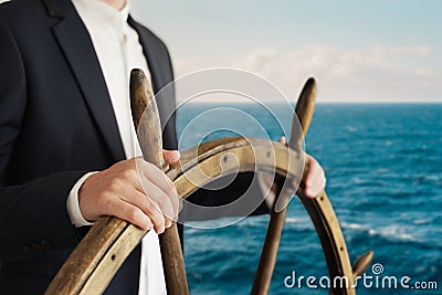 Businessman holding ship rudder and navigates Stock Photo