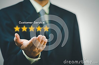 Businessman holding 5 stars on hands.Customer satisfaction and marketing survey rating concept Stock Photo