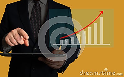 Businessman holding a tablet looking at growing sales volume or stock value increase over the last period. Stock Photo