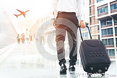 Businessman holding trolley bag going up on travel Stock Photo