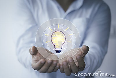 Businessman holding virtual lightbulb glowing on hand for creative thinking idea and innovative technology concept Stock Photo