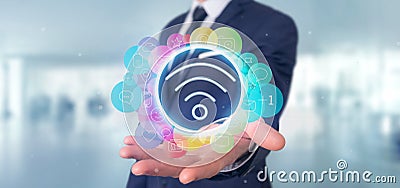 Businessman holding Wifi icon surrounding by colorfull social me Stock Photo